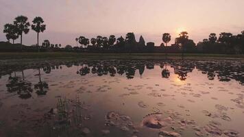 Reflections on lake of beautiful Angkor Wat landmark with tourist in motion in Cambodia visit famous landmark during sunrise video