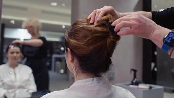 ein schließen oben von ein Friseur Lockerung ein weiblich Kunden Haar. Frisur und Haarschnitt Schönheit Verfahren im ein Friseur. hoch Qualität 4k Aufnahmen video