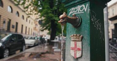 fontän för dricka vatten i de urban stadsbild av milano, Italien. de liv av de stad, vatten flöden från de knacka. hög kvalitet 4k antal fot video