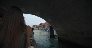 A tourist takes pictures on her phone while sailing on a boat along the canals of Venice. Happy weekend in the city of romance. High quality 4k footage video