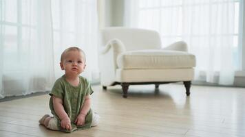 Happy baby. Cute little newborn girl with smiling face crawling on floor in bedroom. Infant baby resting playing in living room indoor at home. Motherhood happy child childcare concept video