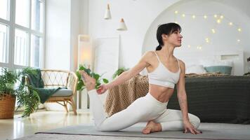 yoga geschiktheid training opleiding. vrouw beoefenen yoga Bij huis. vrouw aan het doen sport- oefening Aan yoga mat Aan verdieping binnen. meisje in sportkleding hebben opleiding training voor gewicht verlies. sport en geschiktheid video