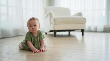 Happy baby. Cute little newborn girl with smiling face crawling on floor in bedroom. Infant baby resting playing in living room indoor at home. Motherhood happy child childcare concept video