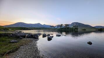 orilla del lago paisaje puesta de sol paisaje de doce pinos isla, derryclare lago a connemara, Galway Irlanda, naturaleza antecedentes foto