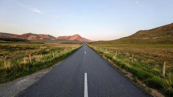 Empty scenic road trough nature and mountains at sunset, Inagh valley, Connemara, Galway, Ireland, landscape background, wallpaper photo