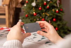 Christmas shopping with credit card. Woman holding online payment gift card. Holiday business pay photo