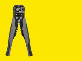 Electrician tool, wire stripper for cable stripping, network installing. Yellow background with copy photo