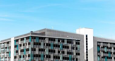 Urban residential building, tall multistory apartment block. Outdoor city structure with blue sky, photo