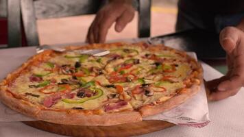 Waiter Bringing and Putting on Table Ordered large delicious pizza in greek tavern. Table setting. Customer service. Pizza with different toppings for a group of people. Mushrooms, piper, cheese, ham video