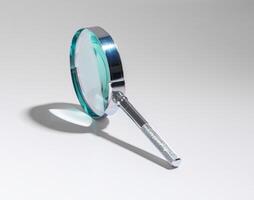 Office work with magnifying glass to inspect, analyze documents. Business analysis, data research, photo