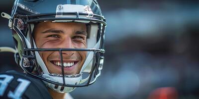 An American football player in a gray helmet and uniform is smiling. Close-up of the face. Copy space photo