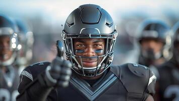 americano fútbol americano jugador en un negro casco y uniforme sonrisas y da un pulgares arriba foto