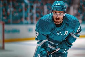 A hockey player in a turquoise uniform and helmet. Playing in the hockey arena photo