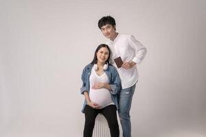 retrato de hermosa embarazada mujer y marido de viaje terminado blanco antecedentes estudio, seguro y maternidad concepto foto