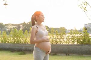 Portrait of Beautiful pregnant woman in the park, Healthy and active pregnancy lifestyle concept. photo