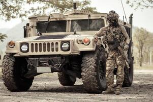 unido estados Ejército en camuflaje uniformes operación en el bosque con blindado vehículo, soldados formación en un militar operación foto