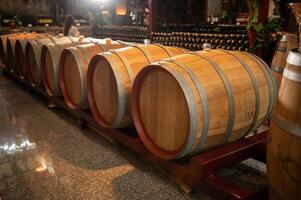 Old wooden wine barrels stacked in a cellar in order photo