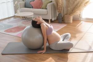 Healthy pregnant woman exercising and doing prenatal yoga, meditation, working out, yoga, pregnancy concept. photo