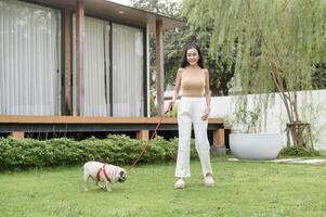 Happy asian woman playing with Cute Smart pug Puppy Dog In the Backyard photo