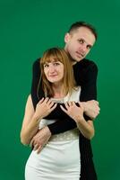 Young attractive business people in formal, black and white clothes. On a green background photo