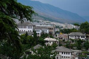 Fortress in Gjirokastra a huge stone building on a high mountain in Albania with a clock the history of the Middle Ages a beautiful view from the stone city to the ancient village photo