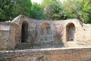 restos de el genial basílica en butrinto nacional parque, butroto, albania triconca palacio a butrinto vida y muerte de un antiguo romano casa histórico medieval veneciano torre rodeado foto