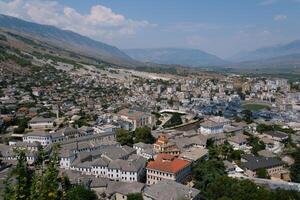 Fortress in Gjirokastra a huge stone building on a high mountain in Albania with a clock the history of the Middle Ages a beautiful view from the stone city to the ancient village photo