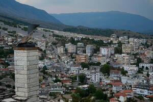 Fortress in Gjirokastra a huge stone building on a high mountain in Albania with a clock the history of the Middle Ages a beautiful view from the stone city to the ancient village photo