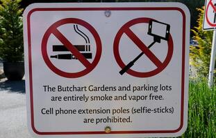 firmar indicando un prohibición en de fumar y tomando imágenes con un selfie pegarse famoso jardines de carnicero en victoria isla. Canadá. el butchart jardines foto