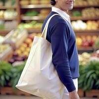 Man holding reusable white blank tote bag shopping in market or groceries store photo