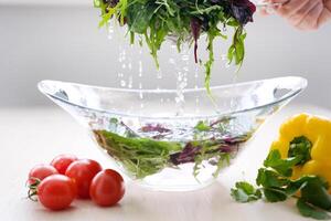 pour water and wash vegetables greens on table in glass plate cooking delicious healthy food cleanliness kill germs refresh clean kitchen Super Shot of Flying Cuts of Colorful Vegetables Water Drops photo