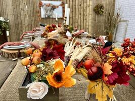 Wooden huge Table massive on which there are devices on wooden stands Mystical mysterious Halloween crows and other golden birds sit on the table Autumn bright orange and yellow flowers dry up photo