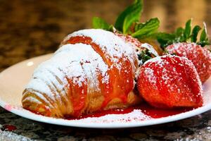 close-up of croissant sprinkled serving cook at home decorate many different videos with strawberries and chocolate sprinkled with syrup sprinkled with different toppings photos and videos