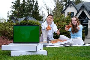 adolescente estudiantes chico y un niña en un almuerzo descanso a escuela. selectivo atención joven Adolescente Pareja en blanco camisas teniendo picnic en girasol campo en puesta de sol. comiendo Pizza y Bebiendo champán foto