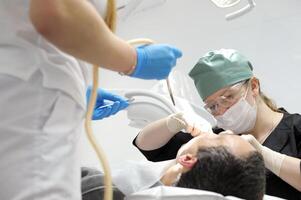 Male Dentist remove tooth of man patient using forceps. Health care dentistry medicine concept. remove a tooth photo