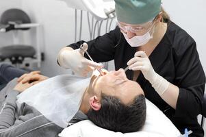 odontología oficina herramientas mujer médico inyecta anestesia con compartir jeringuilla a paciente dental operación foto