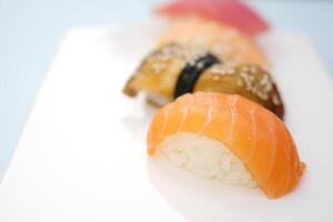 asiático japonés comida delicioso restaurante hermosa servicio blanco porcelana plato blanco antecedentes Sushi conjunto sashimi atún camarón Anguila rojo pescado salmón conjunto de sashimi Sushi con soja y palillos foto