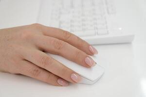 female hand on a white mouse near the keyboard white background space for advertising office work latest technology cleanliness beautiful photo