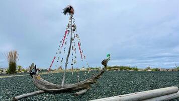 Handmade ship made from dry branches Seashell beads and a pirate flag Against the backdrop of the ocean The wind blows the shiny hair of the head that is worn at the main match Place for text photo