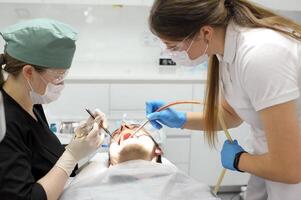 mujer dentista en el médico dental oficina. ella es cura paciente foto