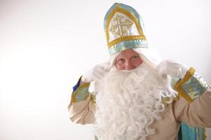 different positive emotions of St. Nicholas the Wonderworker who was founder of Santa Claus St. Nicholas is popularly called he is dressed in turquoise suit with gold with traditional religious cap photo