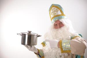 The Father Santa Claus holding a kitchen pan ready for serving or to be delivered take away with special care. Festive culinary preparation background. Happy New Year photo