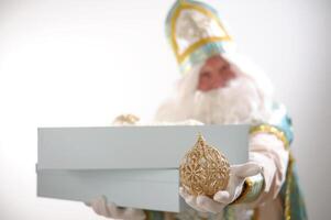 Fairy tale 12 months Nicholas the Wonderworker Waving his hand holds boxes and points at them with his finger then shows the class and opens Saint Nicholas, the founder of Santa Freezing Moroz photo