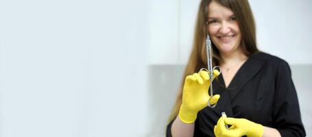 Black clothes long flowing hair white cabinet office dentistry Young girl woman with syringe in hand anaesthesia yellow gloves doctor nurse Doctor, girl, syringe injection photo