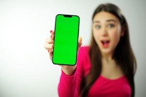 girl phone chromakey delight a woman in a pink sweater with multi-colored manicure long hair is happy showing her phone she has blue eyes she is happy advertising was looking for what she found photo