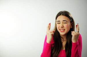 el niña cruzado dos dedos cerca su cabeza y es muy preocupado ese todo será trabajo fuera sincero sonrisa hermosa dientes Fresco bueno ella tiene emocionalmente positivo emociones largo En Vivo natural pelo rosado foto