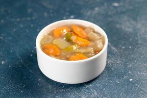 chinese mixed vegetables with capsicum, tomato, carrot, and radish served in bowl isolated on navy blue background closeup side view of bangladeshi food photo