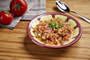 Izma Salad or ezme, red pepper and tomato salad served in dish isolated on table side view of middle east food photo