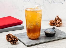 han tian ai jade pequeño perilla con hielo té servido en desechable vaso aislado en tablero lado ver de taiwanés con hielo bebida foto