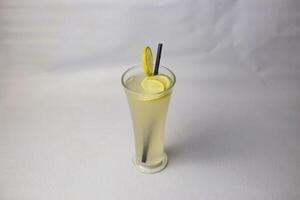 Lemon Juice or lime water with straw served in glass isolated on grey background side view of healthy drink photo